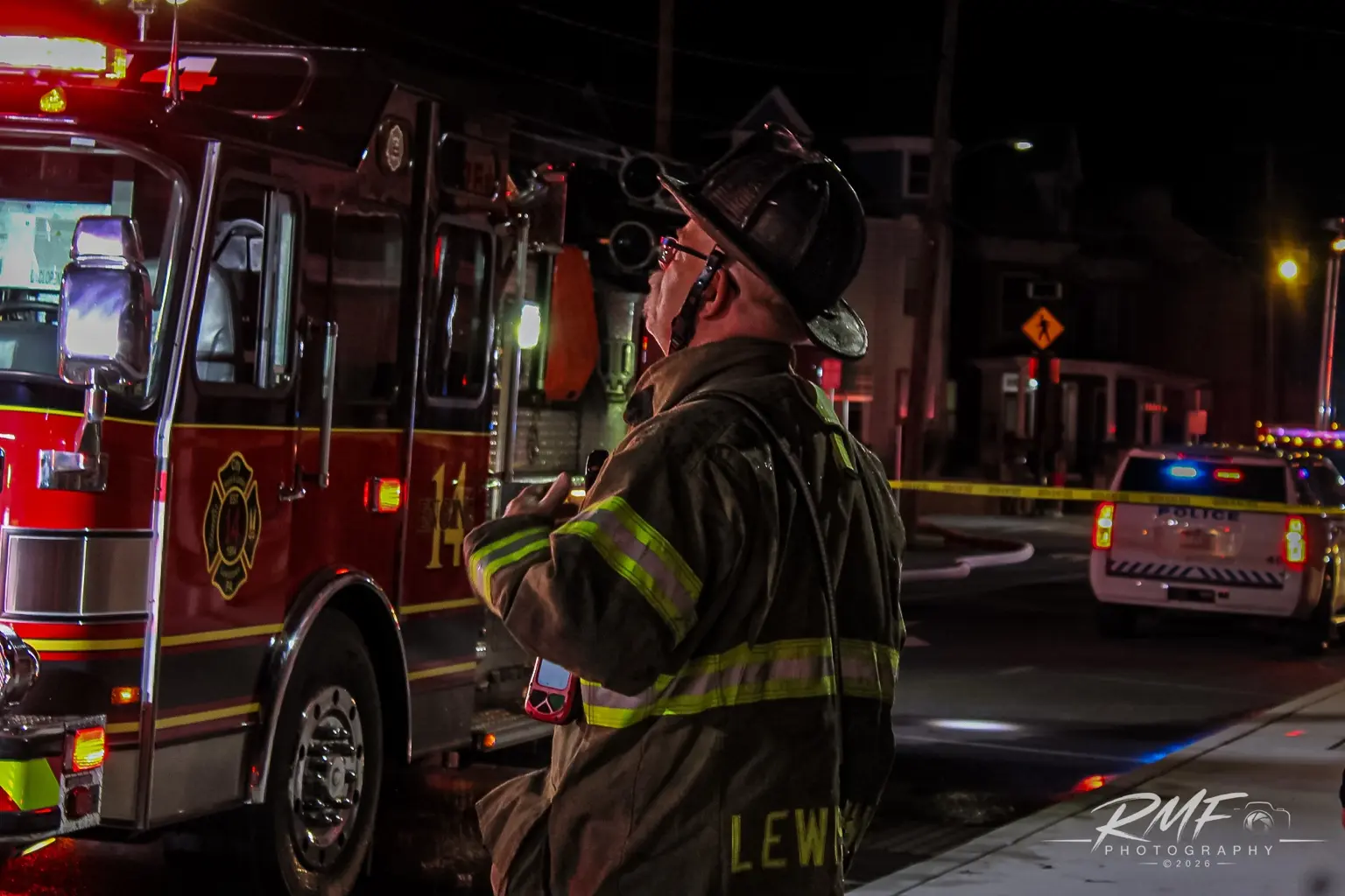 Firefighter beside apparatus at a nighttime incident