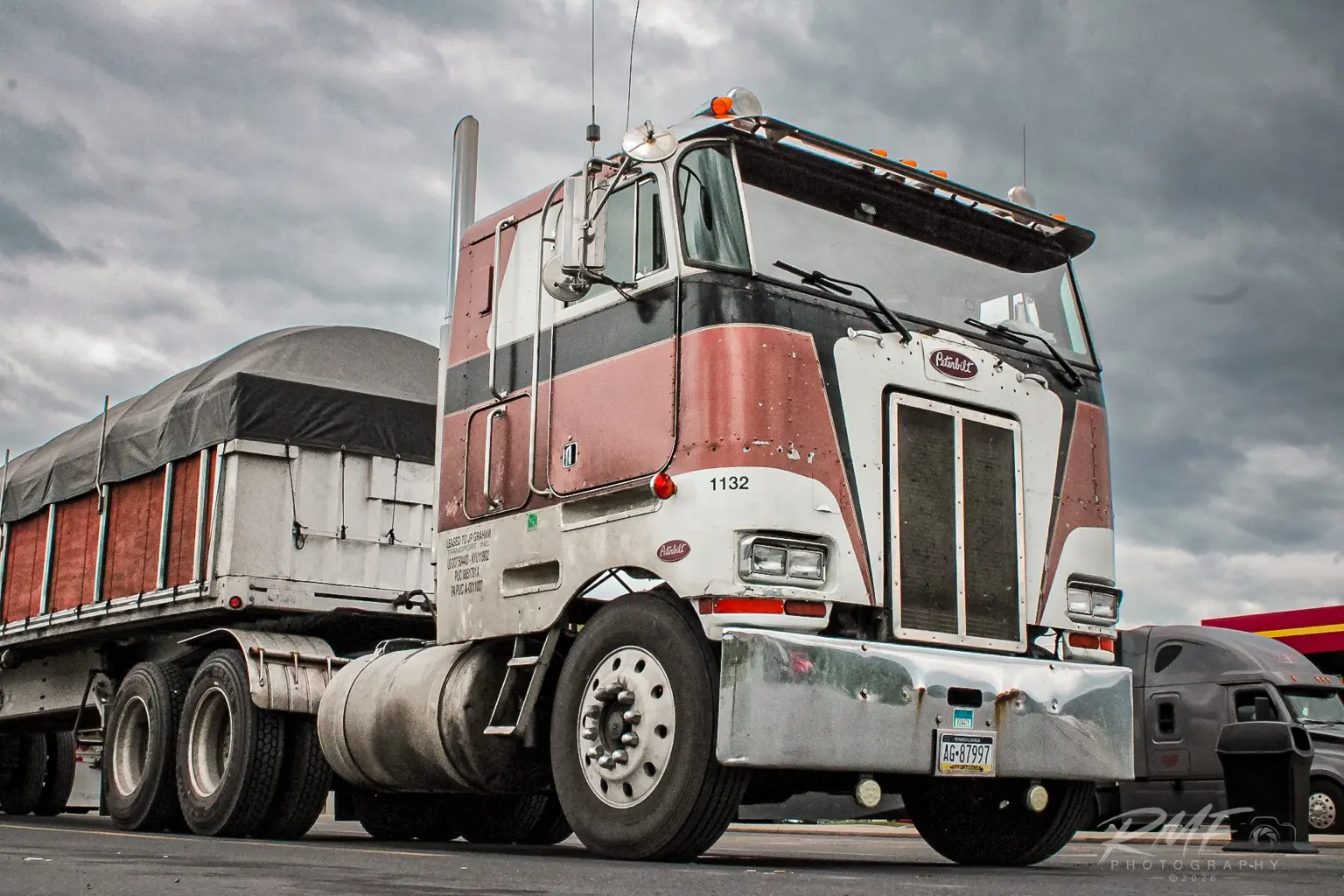 Classic cabover dump truck beneath dramatic clouds
