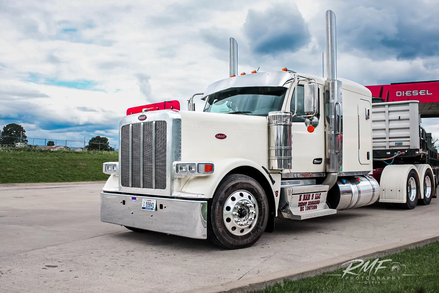 White Peterbilt tractor photographed beneath a dramatic sky
