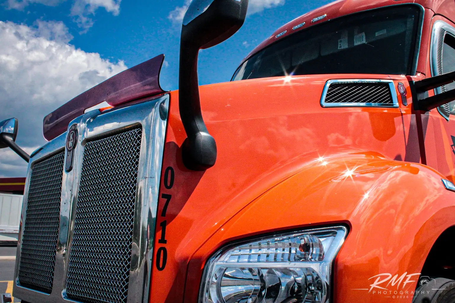 Close detail of a bright orange Kenworth truck