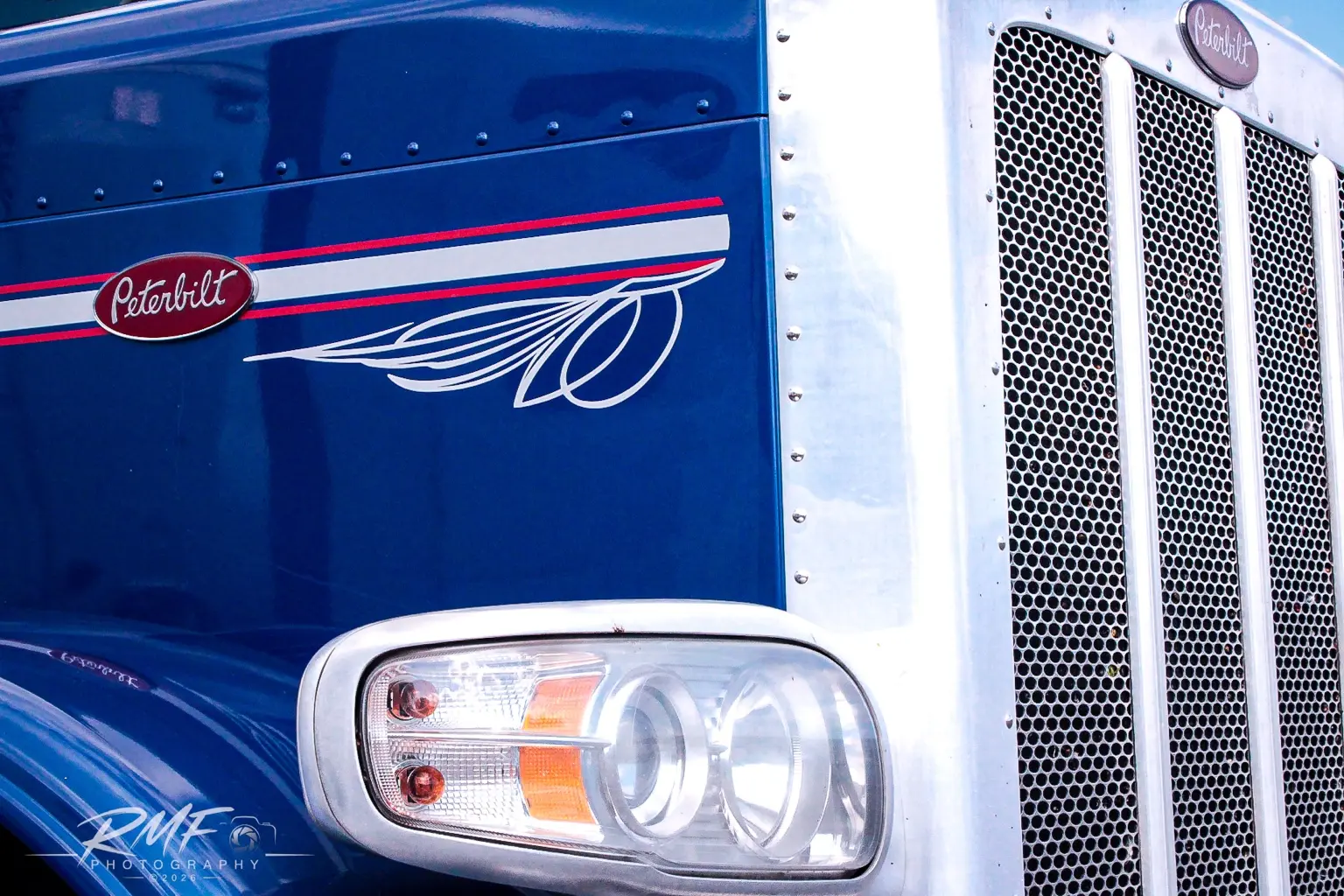 Blue Peterbilt headlight and grille detail
