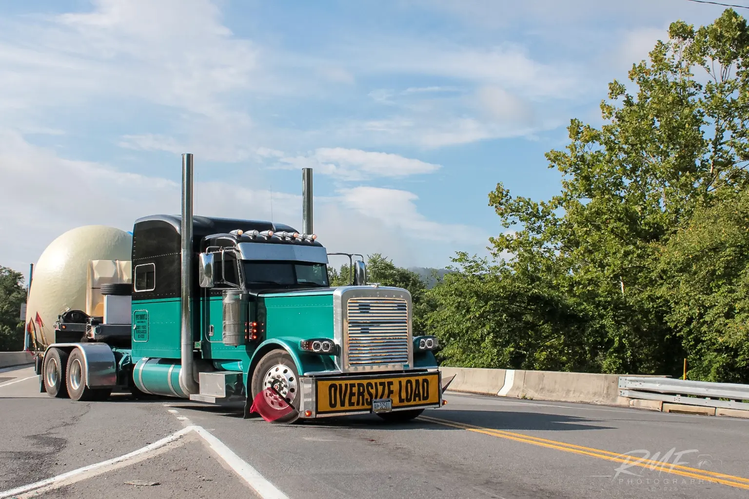 Green tractor hauling an oversized load