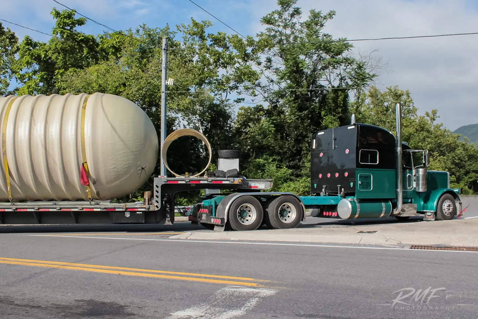 Green tractor and tank trailer traveling through Central Pennsylvania