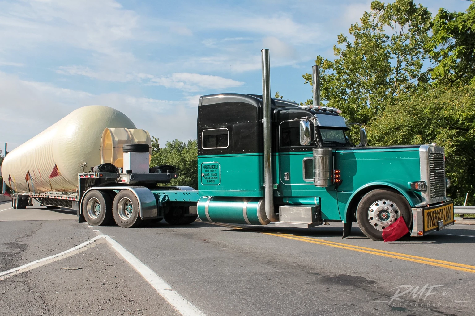 Green Peterbilt tractor hauling an oversized tank through Central Pennsylvania