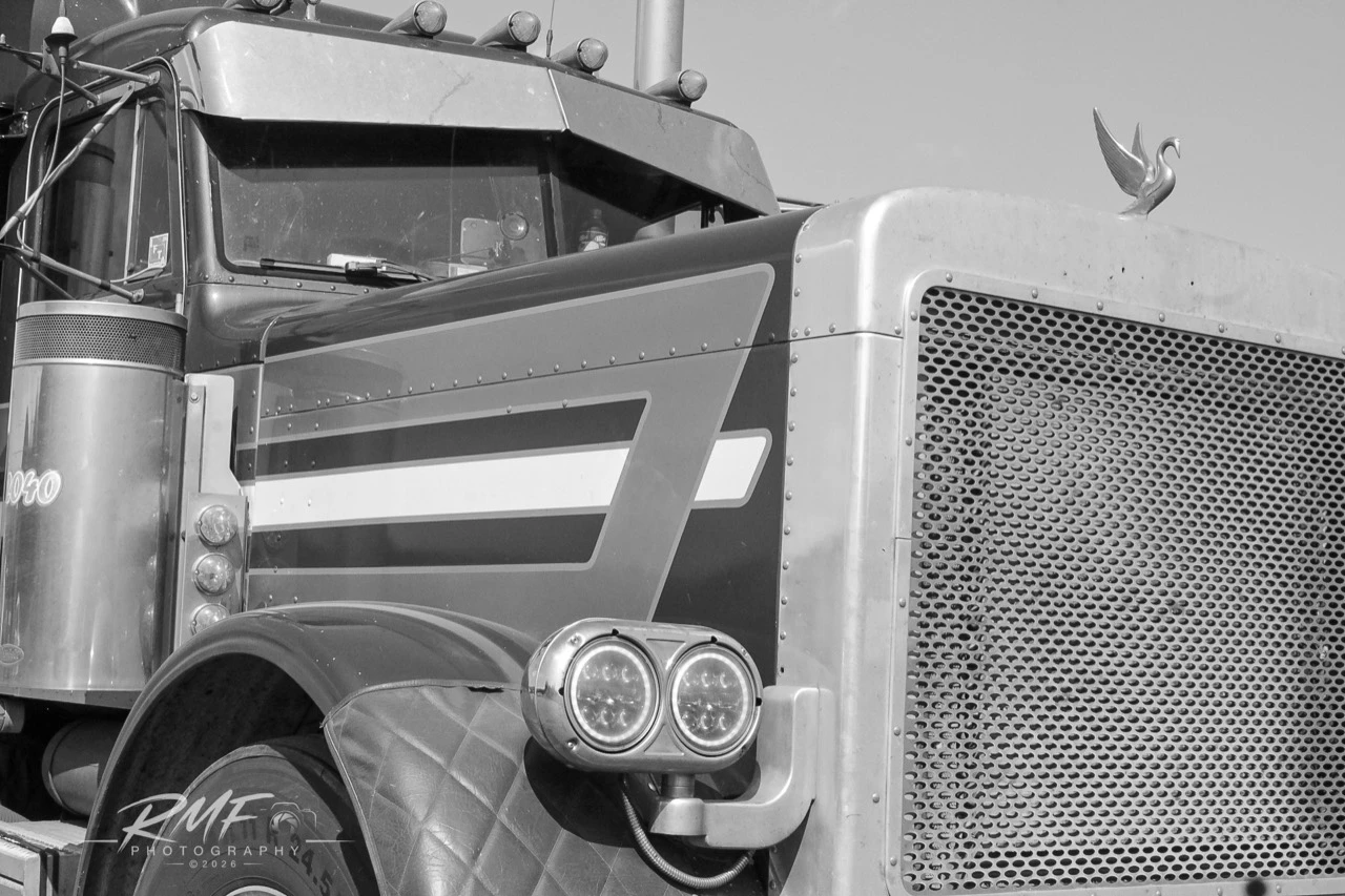 Black-and-white close detail of a maroon classic long-nose truck